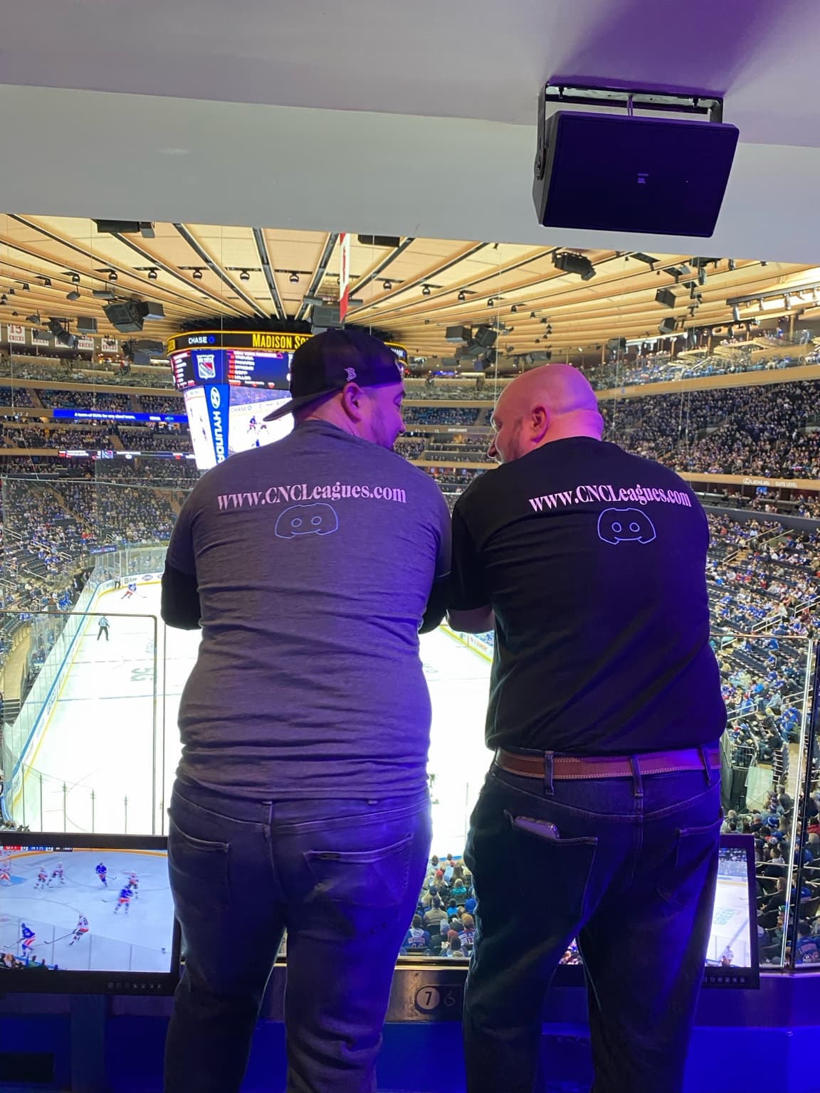 TJ and Scottie overlooking the rink in shirts bearing the CNC Leagues website